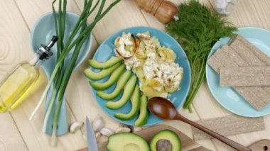 Düz yerde yemek vardı. Peynirli fırında patates ve avokado. Sağlıklı vejetaryen gıda kavramı. Taze otlarla süslenmiş.
