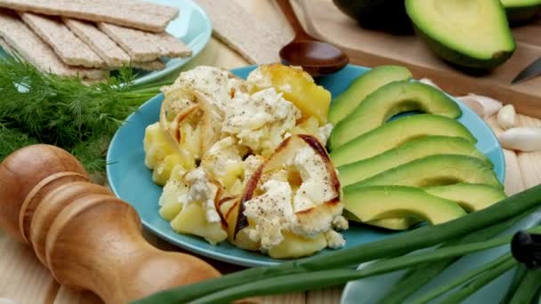 Cazuela al horno con patatas y rodajas de aguacate de queso de cerca — Vídeos de Stock