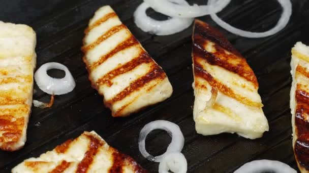 Kaas bakken in een pan met uienringen in boter. Bovenaanzicht — Stockvideo