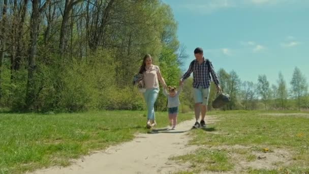 Familia feliz descansando en la naturaleza cerca del bosque — Vídeo de stock