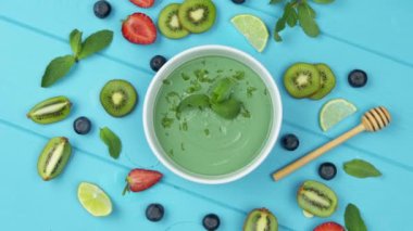 Meyve, böğürtlen ve kiviyle kaplanmış sağlıklı kahvaltı içeceği kasesi. Detox smoothie kasesi. Üst görünüm.