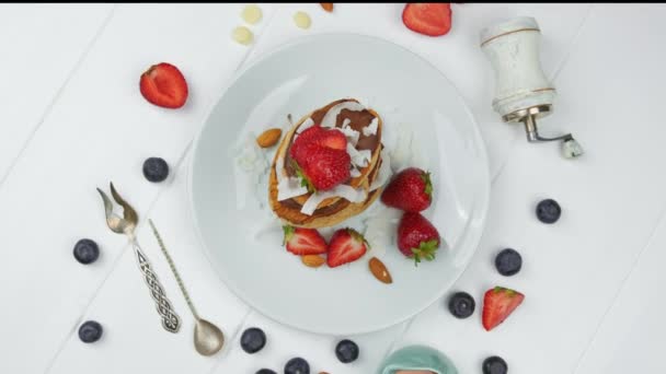 Söta pannkakor choklad jordgubbe ovanifrån. vit bakgrund — Stockvideo