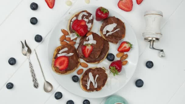 Söta pannkakor choklad jordgubbe ovanifrån. vit bakgrund — Stockvideo