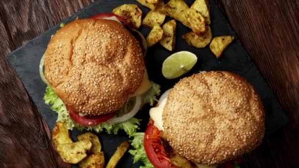 Verse veganistische hamburger met frietjes. houten achtergrond. Bovenaanzicht — Stockvideo