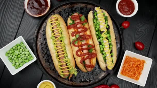 野菜のホットドッグは、木の背景にトマト、アバカド、玉ねぎ、パンを添えています。トップビュー、フラットレイアウト — ストック動画
