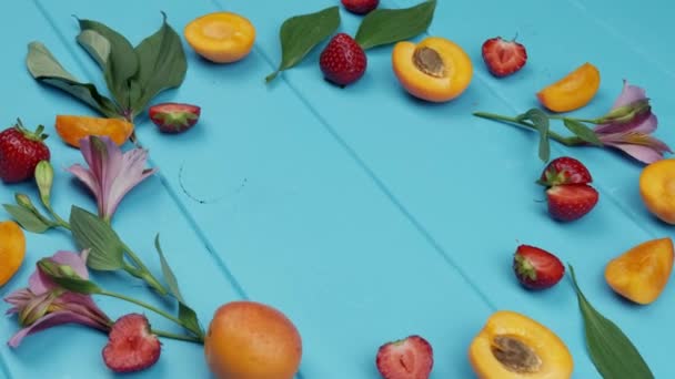 青い木製の背景にイチゴをアプリコット。テキストの空間 — ストック動画