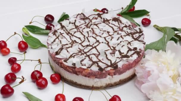 Pastel blanco con bayas rojas maduras en la mesa de madera blanca. vista superior desde arriba — Vídeos de Stock