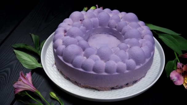 蓝莓素食芝士蛋糕在黑色的背景上，生蛋糕，白盘上有新鲜的浆果。平铺 — 图库视频影像