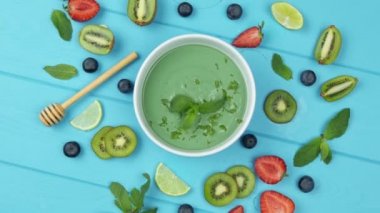 Meyve, böğürtlen ve kiviyle kaplanmış sağlıklı kahvaltı içeceği kasesi. Detox smoothie kasesi. Üst görünüm.