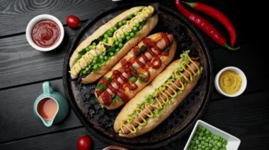 Domates, avacado, soğan ve çöreklerle servis edilen vejetaryen sosislileri ahşap arka planda. Üst manzara, düz uzanma