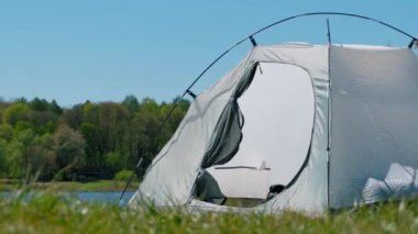 Çam ormanının arka planında gri turist çadırı. Ön kapı..