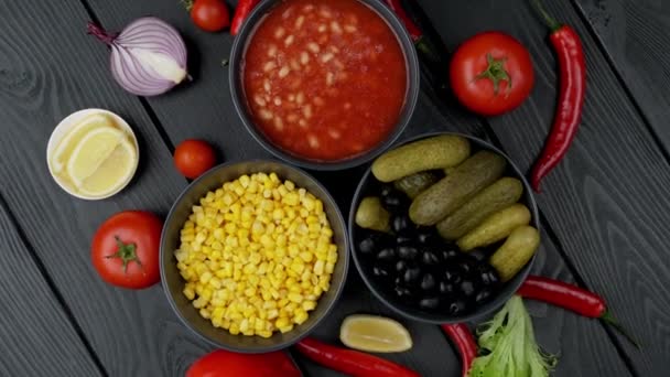 Legumes enlatados em um prato. pepino, milho, feijão. Em uma placa preta — Vídeo de Stock