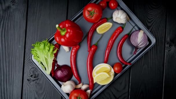 Ingredients for hot tomato sauce on a black background — Stock Video