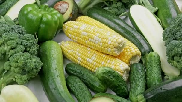 A tabletop arrangement of a variety of fresh fruits and vegetables sorted by colors pepper, corn , green salad, , eggplant, cucumber. Healthy food concept — 图库视频影像