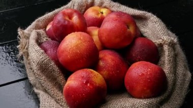 Çuval beziyle masada tatlı nektarinler. organik meyve