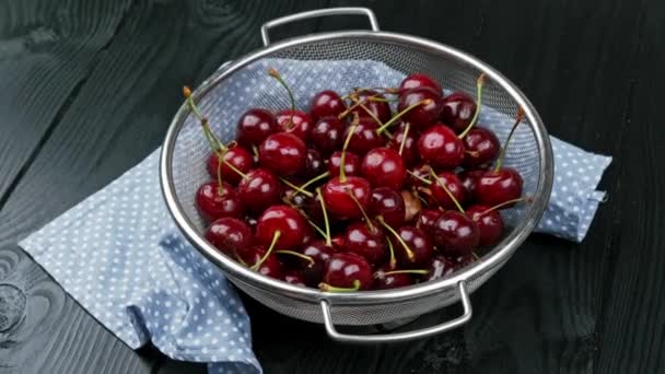 Un tazón de cerezas recién lavadas. fondo de madera negro — Vídeos de Stock