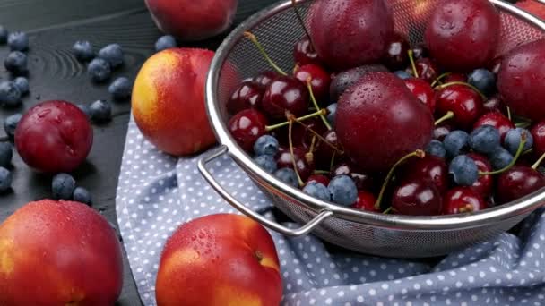 Pesche noci, ciliegie dolci, mirtilli su un tavolo di legno, raccolta autunnale in estate — Video Stock
