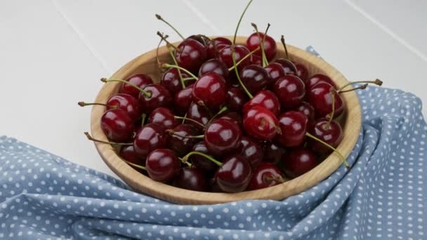 Una ciotola di ciliegie appena lavate. Fondo in legno bianco — Video Stock