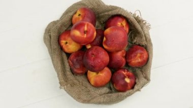 Çuval beziyle masada tatlı şeftaliler. organik meyve