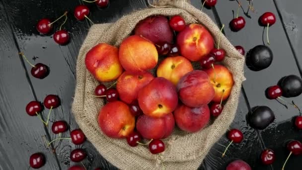 Nektarinky, sladké třešně, borůvky na dřevěném stole, podzimní sklizeň v létě — Stock video
