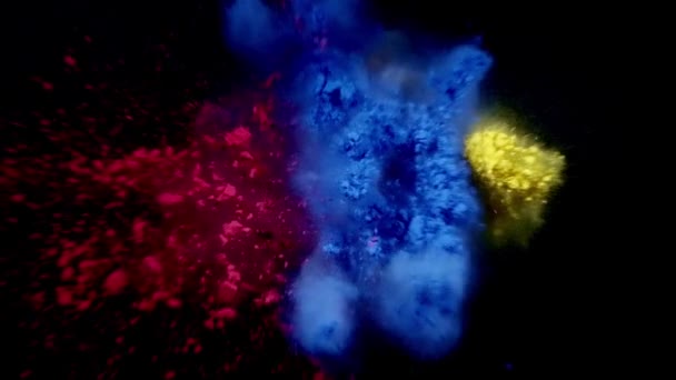 Kék, piros és sárga por színrobbanása. fekete háttér — Stock videók