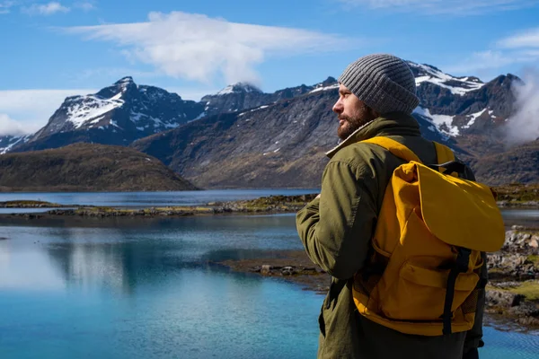 Guy viaja con una mochila amarilla a través de pintorescos lugares con hermosos paisajes de montaña. — Foto de Stock