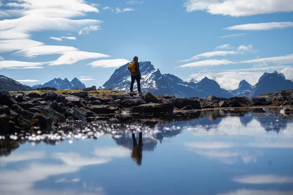 Guy cestuje se žlutým batohem přes malebná místa s krásnou horskou krajinou. — Stock fotografie