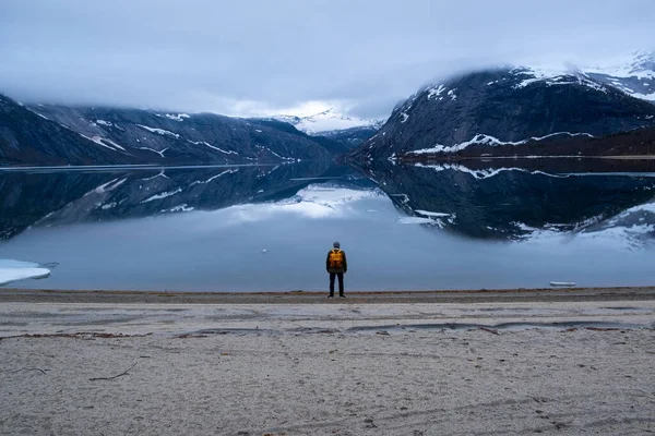 Mies turisti seisoo suuri vuori Skandinavian luonto — kuvapankkivalokuva