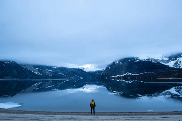 Mies turisti seisoo suuri vuori Skandinavian luonto — kuvapankkivalokuva
