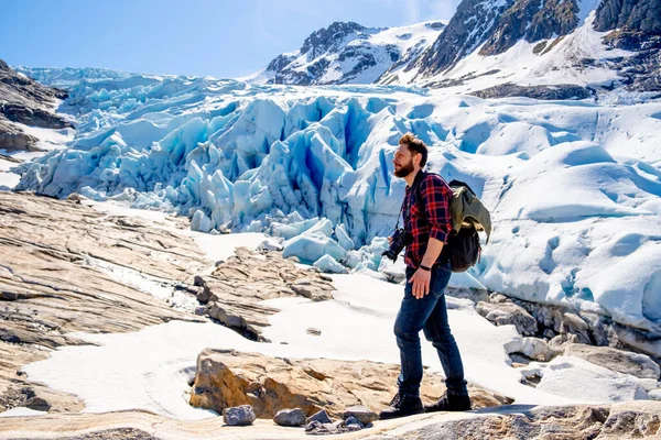 Mies turisti seisoo suuri vuori Skandinavian luonto tekijänoikeusvapaita valokuvia kuvapankista