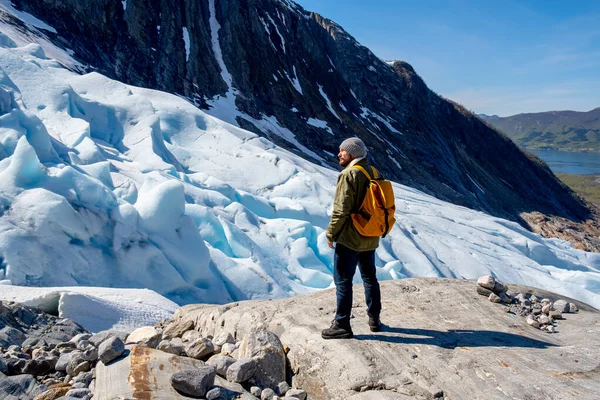 Mies turisti seisoo suuri vuori Skandinavian luonto — kuvapankkivalokuva