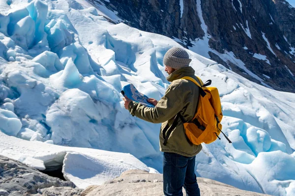 Mies turisti seisoo suuri vuori Skandinavian luonto kuvapankkikuva