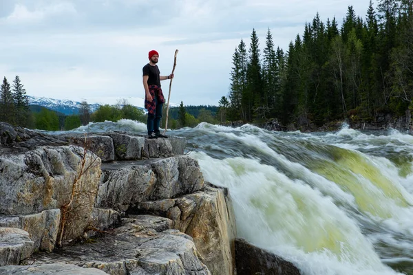 Mies turisti seisoo suuri vuori Skandinavian luonto tekijänoikeusvapaita kuvapankkikuvia