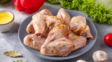 Baharatla marine edilmiş çiğ tavuk kanadı.