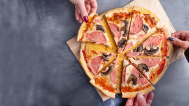 İnsanlar mantarlı ve jambonlu pizza yiyorlar. Üst görünüm, metin alanı