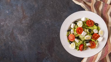 Tabakta sebze salatası: marul, domates, bıldırcın yumurtası, zeytin ve peynir.