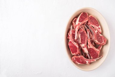 Kemikte taze çiğ koyun eti. Beyaz arka planda pişmemiş kuzu kaburgası. Mesaj için yer var. Uzayı kopyala Üst görünüm