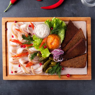 Kızarmış ekmek ve salatalık turşusuyla domuz eti mezesi. Üst görünüm