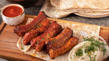 Kırmızı soslu domuz pirzolası ve soğan. Izgara et.