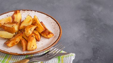 Baharatlı fırında patates dilimleri olan bir yer. Metin uzayı