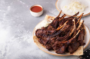 Soğanlı ve tabakta kırmızı soslu barbekü kuzu eti. Metin için boşluk