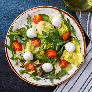 Sağlıklı ve diyet salatasının en iyi görüntüsü. Taze salata roka, marul, vişneli domates ve mozzarella peyniri.. 
