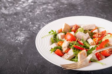 Tavuklu salata, vişneli domates, kırmızı biber ve roka. Sağlıklı gıda konsepti. Yaşam tarzı. Metin için boşluk