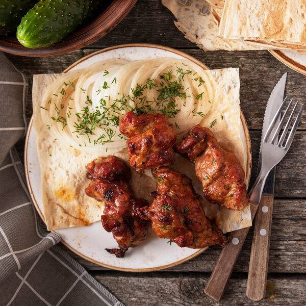 Свиной шашлык с луком и красным соусом. Мясо на гриле. Вид сверху. 