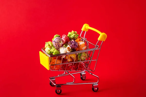 Kleiner Einkaufswagen Mit Popcorn Auf Rotem Hintergrund — Stockfoto