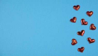 Mavi arka planda kırmızı kalpler. Metin için boşluk