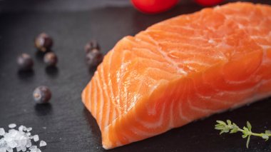 Çiğ somon fileto ve baharatlı siyah bir taş.