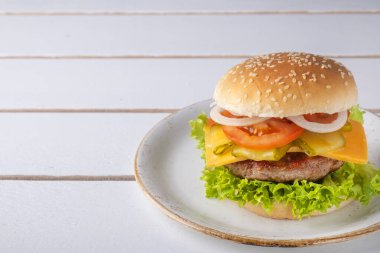 Sığır pirzolası, peynir, soğan, domates ve marullu hamburger. Metin için boşluk