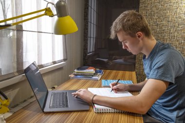 Genç adam evde online öğrenim görüyor.. 