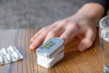 Minsk, Belarus - 9 Mart 2021: kandaki oksijen seviyesini ölçen adam. Nabız oksimetre Beurer